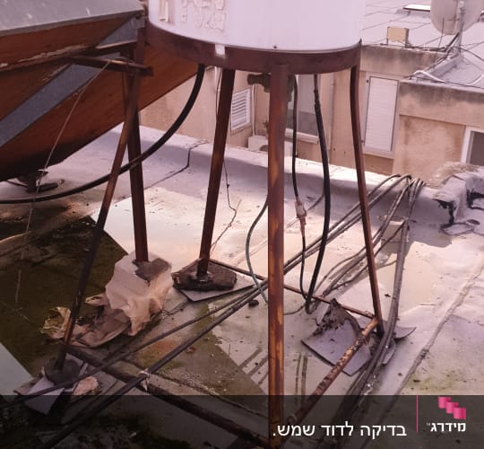 דוד שמש על גג עם צינורות חלודים